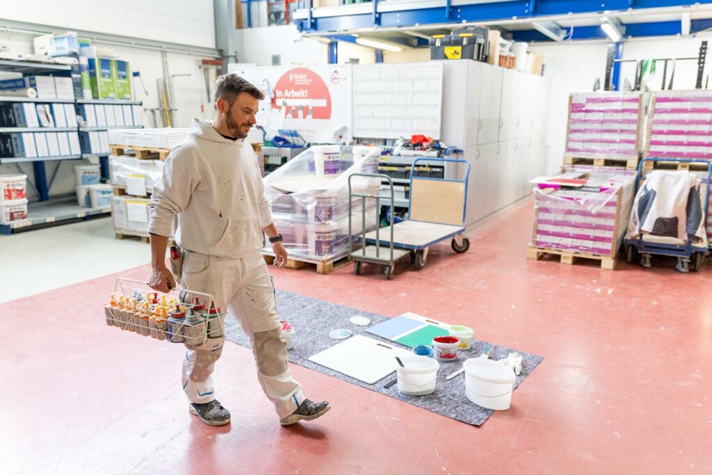 Arbeiter trägt Farbpigmente im Lager