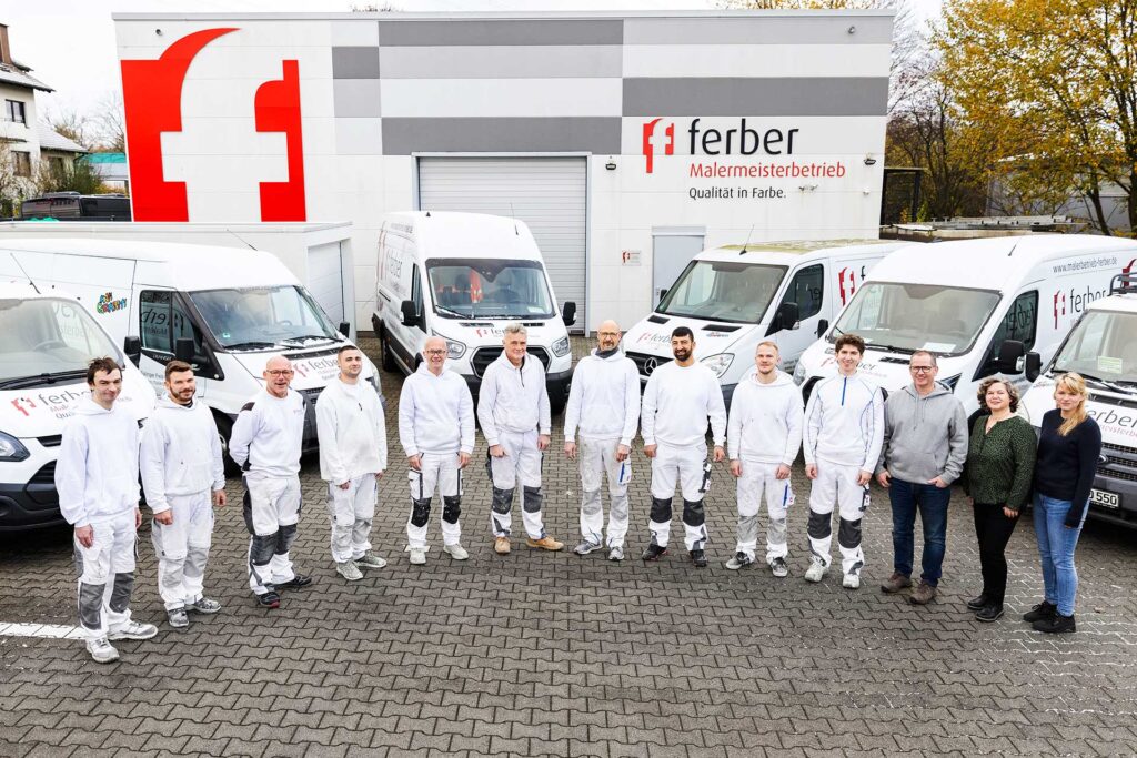 Team vom ferber Malermeisterbetrieb vor Firmenfahrzeugen